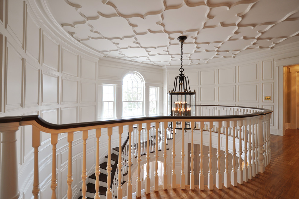 Свежая идея для дизайна: изогнутая лестница в классическом стиле с деревянными ступенями - отличное фото интерьера