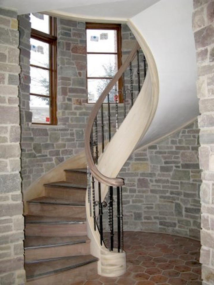 Medium sized traditional wood curved metal railing staircase in Detroit with wood risers.