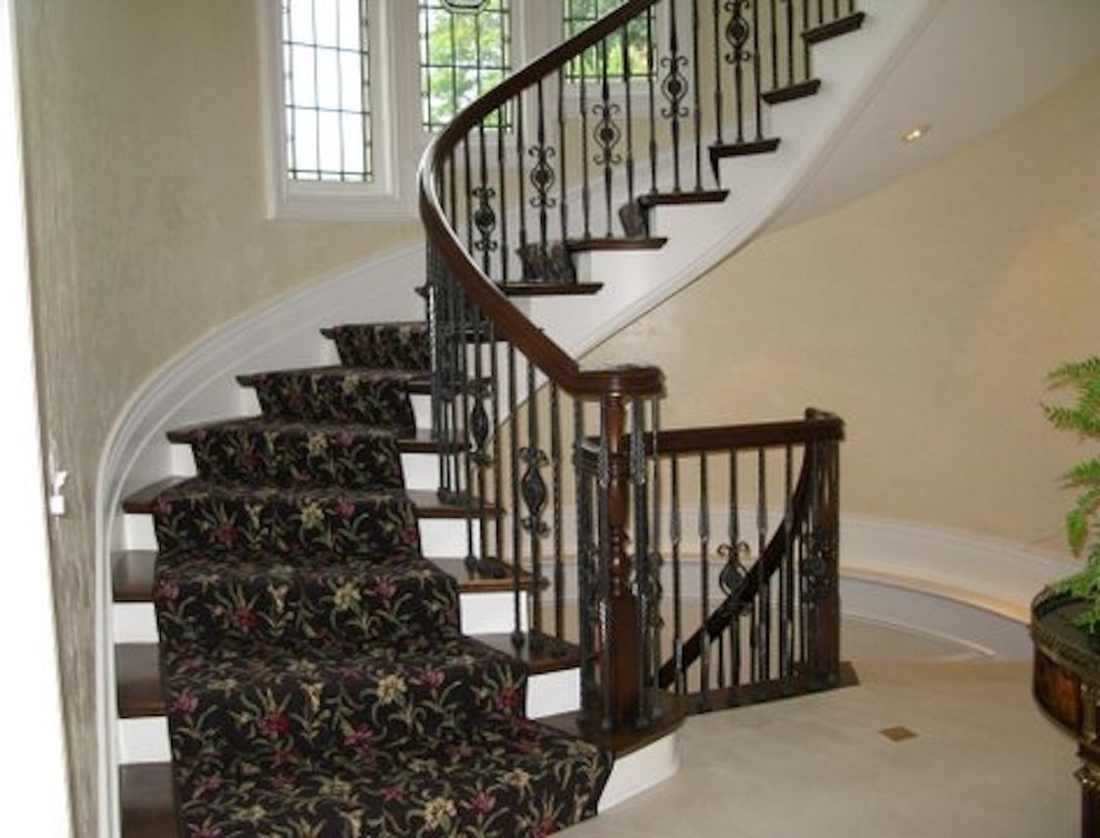 Cette image montre un escalier courbe traditionnel de taille moyenne avec des marches en moquette, des contremarches en moquette et un garde-corps en bois.