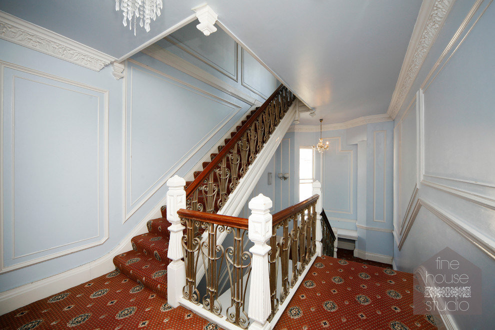 Exempel på en mycket stor klassisk u-trappa, med heltäckningsmatta och sättsteg med heltäckningsmatta