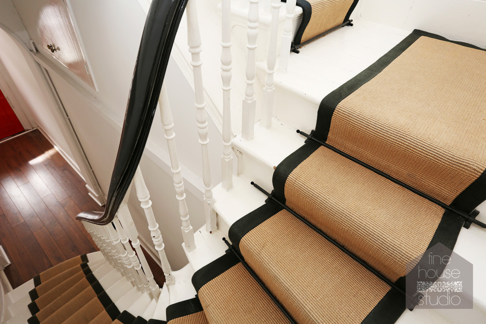 ロンドンにある高級な広いトラディショナルスタイルのおしゃれな折り返し階段 (フローリングの蹴込み板) の写真