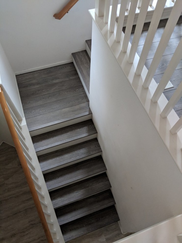 Exemple d'un escalier peint tendance en L de taille moyenne avec des marches en bois et un garde-corps en bois.