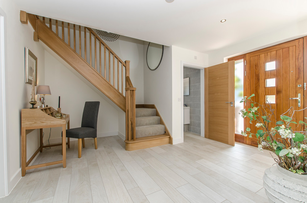 Diseño de escalera en L moderna de tamaño medio con escalones enmoquetados, contrahuellas enmoquetadas y barandilla de madera