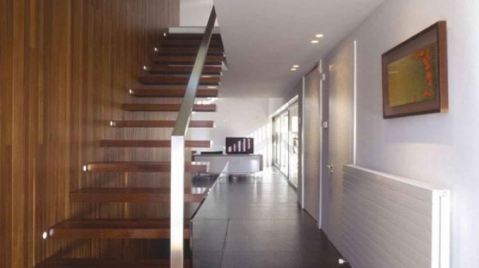 Ejemplo de escalera recta tradicional de tamaño medio sin contrahuella con escalones de madera y barandilla de metal