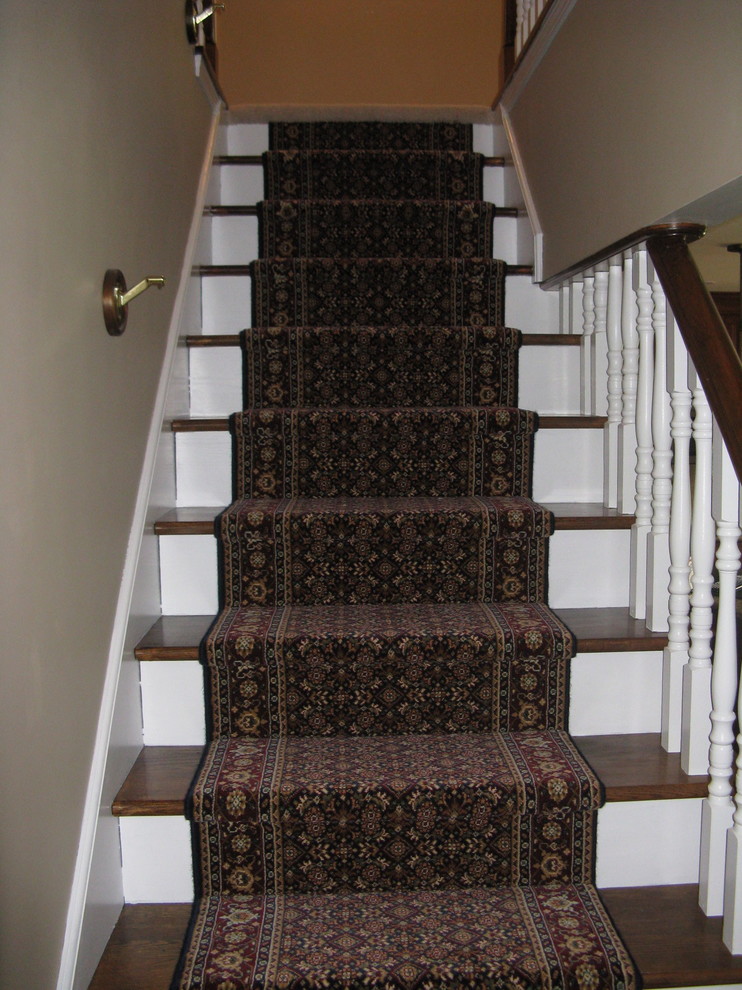 Exempel på en mellanstor klassisk rak trappa, med heltäckningsmatta och sättsteg med heltäckningsmatta