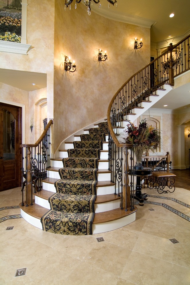 Imagen de escalera curva tradicional con escalones de madera, contrahuellas de madera pintada y barandilla de varios materiales