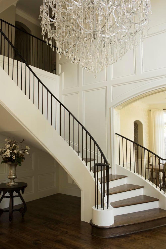 Transitional wooden curved staircase photo in Dallas with wooden risers