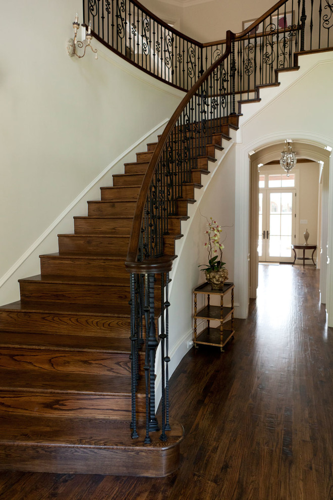 Modelo de escalera curva tradicional con escalones de madera y contrahuellas de madera