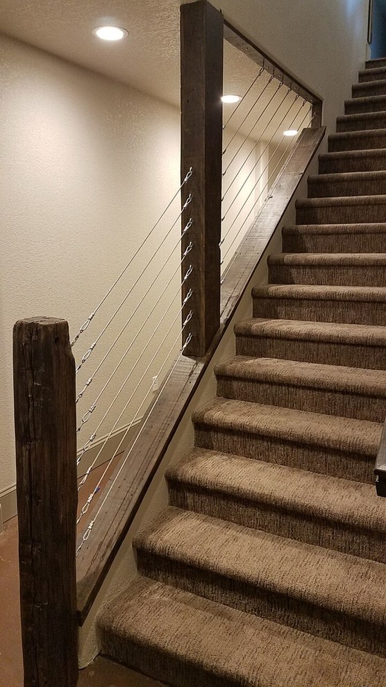 デンバーにある高級な中くらいなラスティックスタイルのおしゃれな直階段 (カーペット張りの蹴込み板、ワイヤーの手すり) の写真