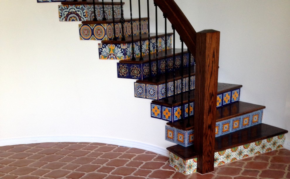 Staircase - mid-sized mediterranean wooden curved staircase idea in San Diego with tile risers