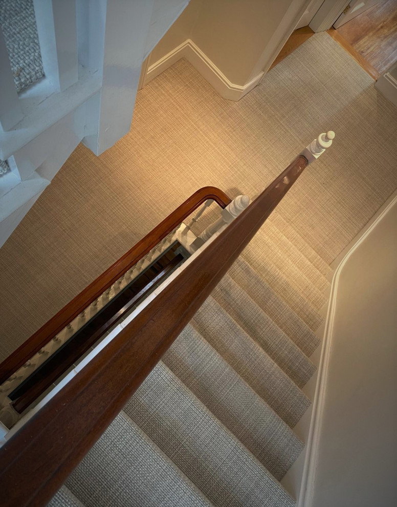 Cette photo montre un grand escalier moderne avec des contremarches en moquette et un garde-corps en bois.