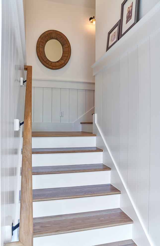 На фото: лестница среднего размера в морском стиле с деревянными ступенями и деревянными перилами с