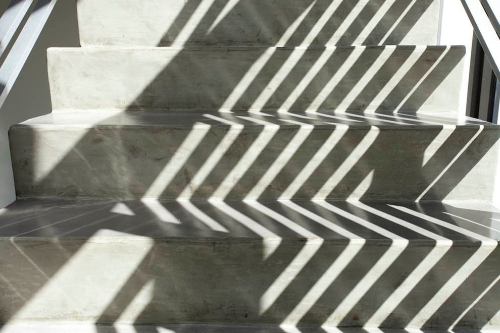 マイアミにある広いコンテンポラリースタイルのおしゃれなかね折れ階段 (コンクリートの蹴込み板) の写真