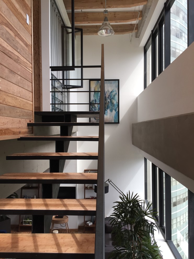 Imagen de escalera suspendida urbana pequeña con escalones de madera, contrahuellas de metal y barandilla de metal