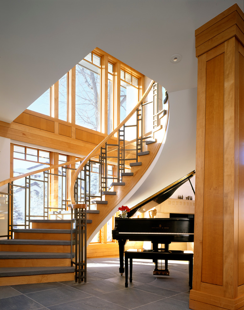 Идея дизайна: огромная изогнутая деревянная лестница в стиле кантри с ступенями с ковровым покрытием