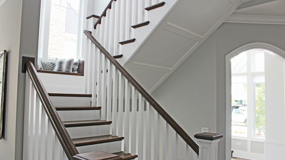 Источник вдохновения для домашнего уюта: большая п-образная лестница в стиле неоклассика (современная классика) с деревянными ступенями, крашенными деревянными подступенками и деревянными перилами
