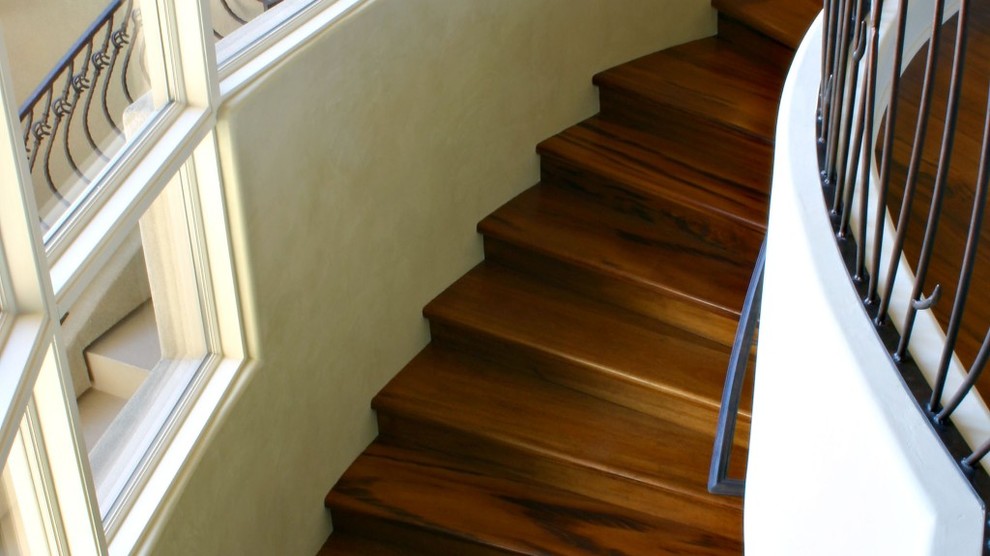 Foto de escalera curva mediterránea grande con escalones de madera y contrahuellas de metal
