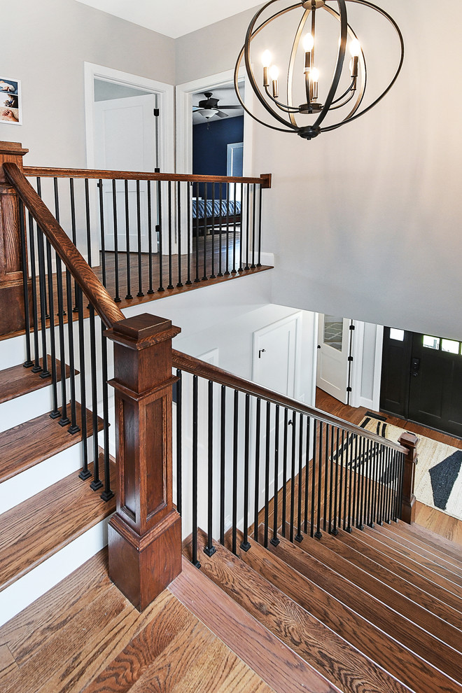 Diseño de escalera en L clásica renovada de tamaño medio con escalones de madera, contrahuellas de madera pintada y barandilla de varios materiales