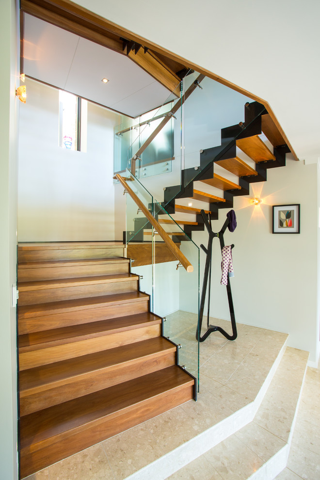Photo of an expansive wood u-shaped staircase in Brisbane with wood risers.