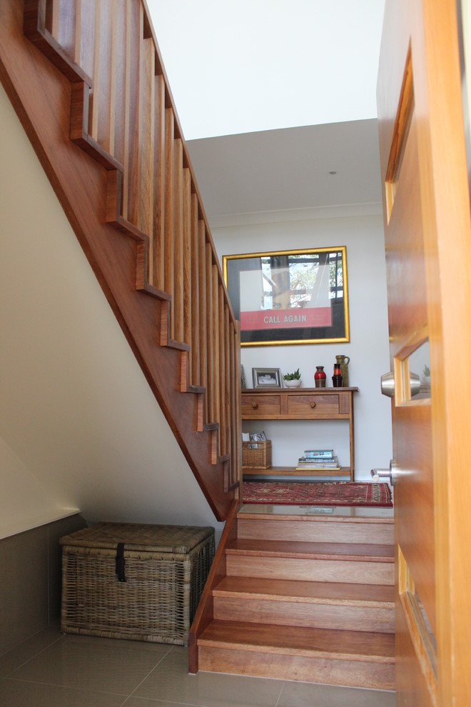 Foto de escalera recta de tamaño medio con escalones de madera y contrahuellas de madera