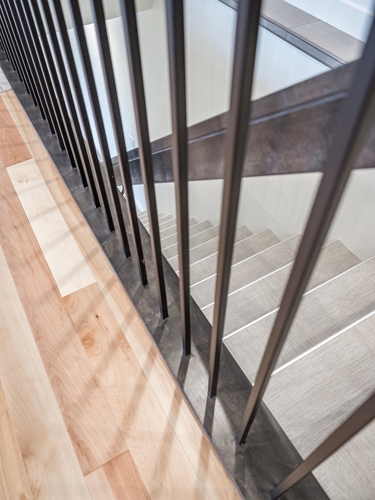 Imagen de escalera recta escandinava de tamaño medio con escalones con baldosas, contrahuellas con baldosas y/o azulejos y barandilla de metal