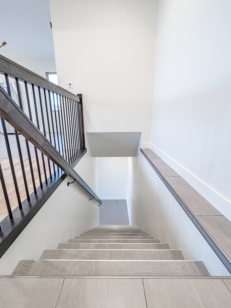 エドモントンにある中くらいな北欧スタイルのおしゃれな直階段 (タイルの蹴込み板、金属の手すり) の写真