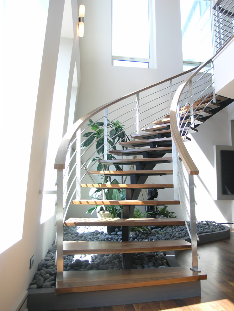 Свежая идея для дизайна: большая изогнутая лестница в стиле модернизм с деревянными ступенями без подступенок - отличное фото интерьера