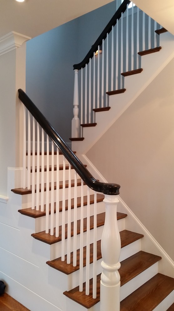 На фото: п-образная лестница среднего размера в классическом стиле с деревянными ступенями, крашенными деревянными подступенками и деревянными перилами