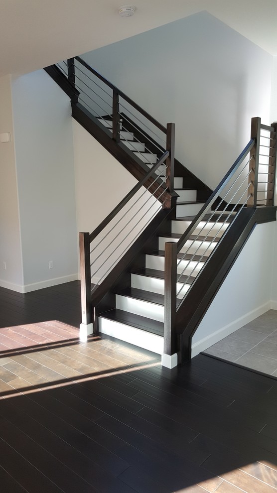 Réalisation d'un escalier peint design en L de taille moyenne avec des marches en bois et un garde-corps en câble.
