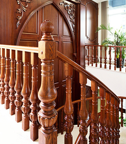 На фото: изогнутая деревянная лестница среднего размера в викторианском стиле с деревянными ступенями с