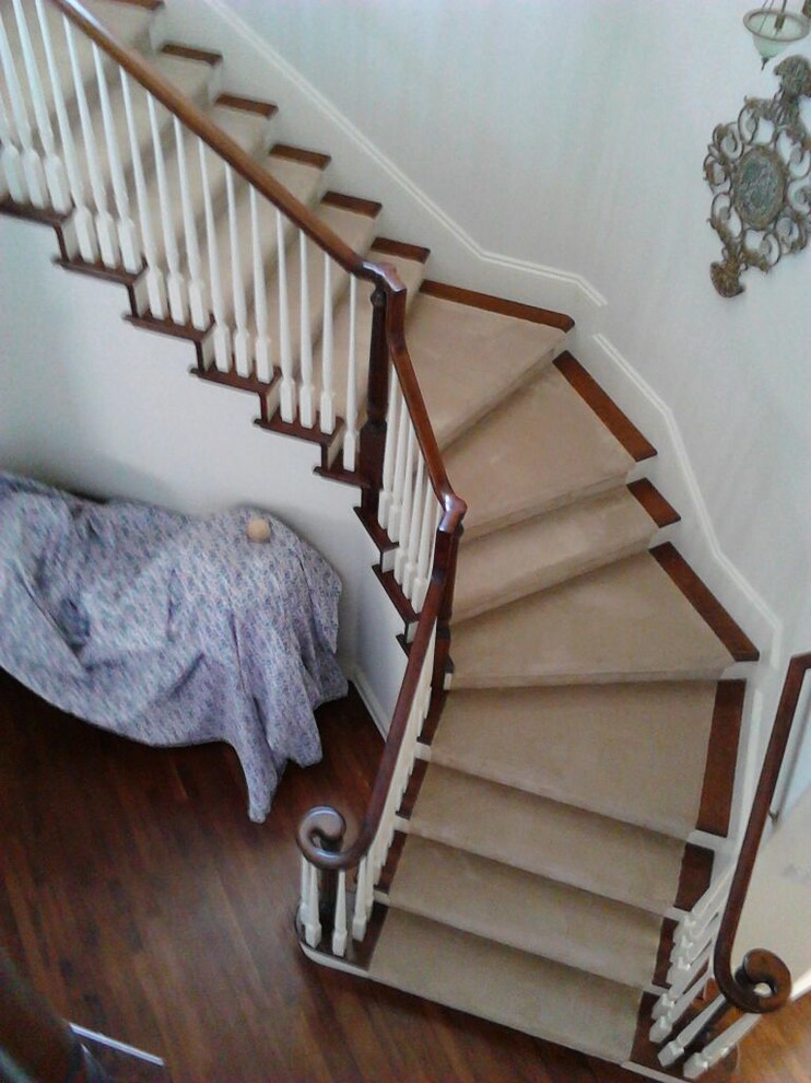Inspiration pour un grand escalier traditionnel en L avec des marches en bois et des contremarches en moquette.
