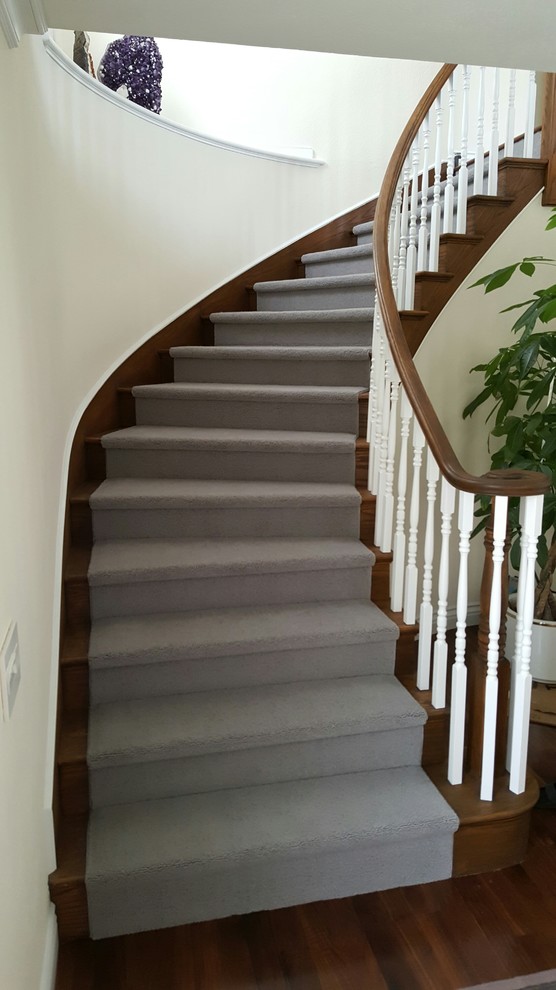 Idée de décoration pour un petit escalier courbe tradition avec des marches en bois et des contremarches en bois.