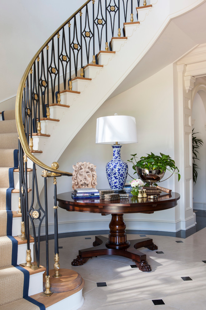 Стильный дизайн: огромная изогнутая лестница в классическом стиле с ступенями с ковровым покрытием и ковровыми подступенками - последний тренд