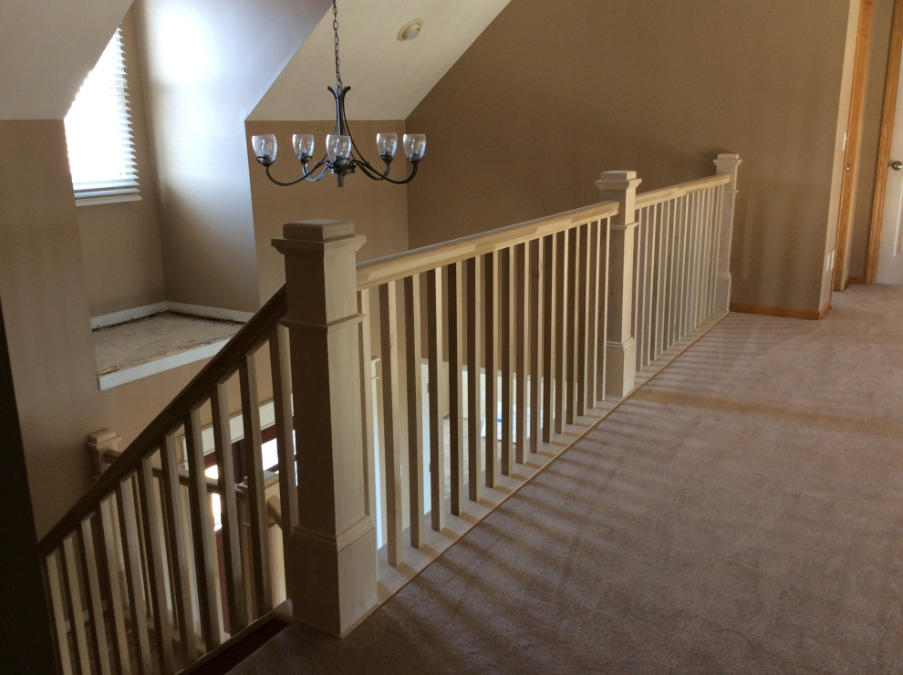 На фото: угловая лестница среднего размера в стиле кантри с ступенями с ковровым покрытием, ковровыми подступенками и деревянными перилами с