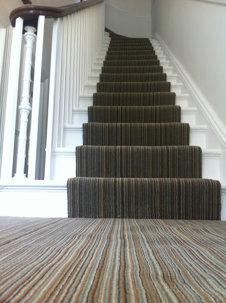 Inspiration for a medium sized eclectic carpeted staircase in London with carpeted risers.