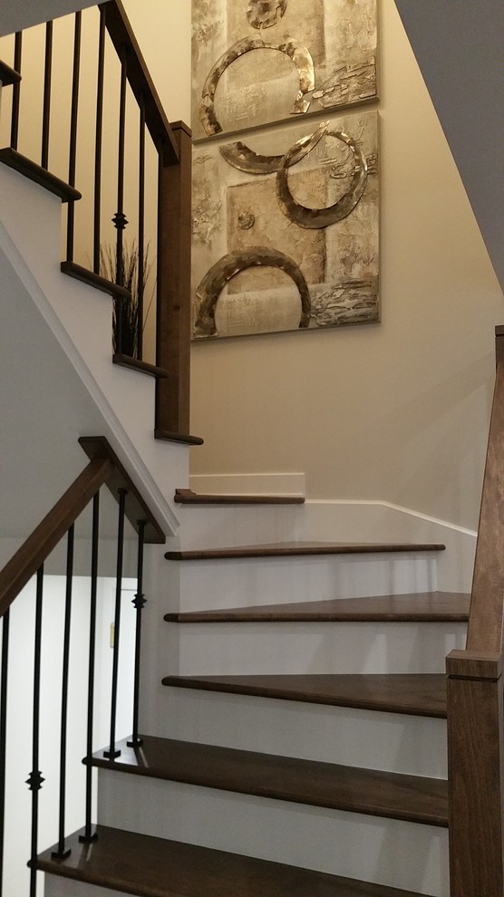 Example of a mid-sized transitional wooden u-shaped wood railing staircase design in Montreal with painted risers