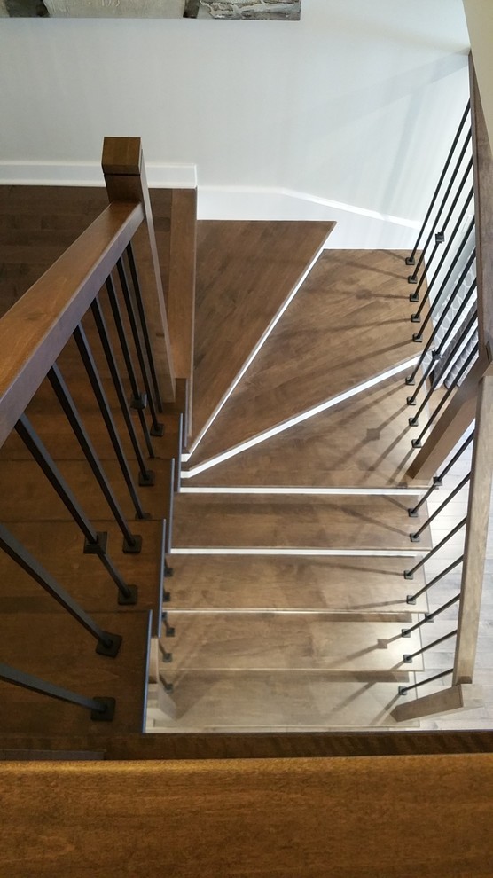 Foto de escalera en U tradicional renovada de tamaño medio con escalones de madera, contrahuellas de madera pintada y barandilla de madera