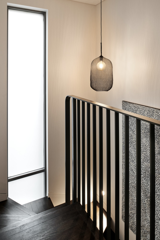 This is an example of a large scandinavian wood u-shaped metal railing staircase in Sydney with wood risers.