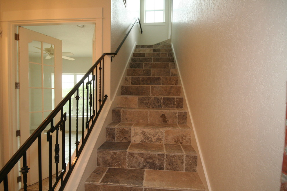 Modelo de escalera en L tradicional pequeña con escalones con baldosas, contrahuellas con baldosas y/o azulejos y barandilla de metal