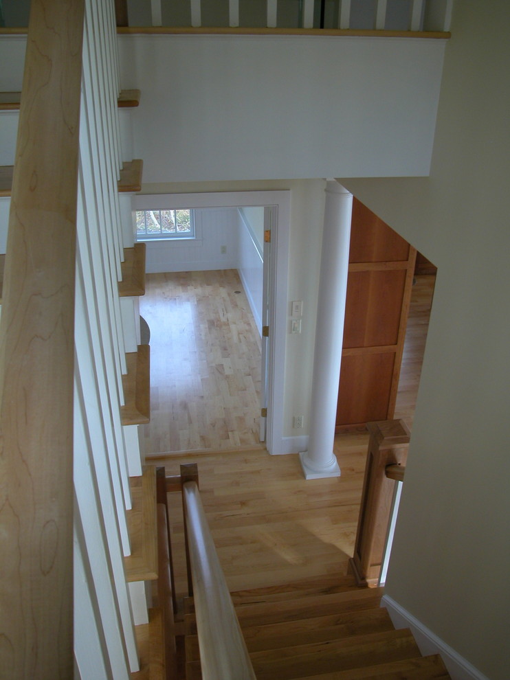 Imagen de escalera en U tradicional grande con escalones de madera, contrahuellas de madera y barandilla de madera