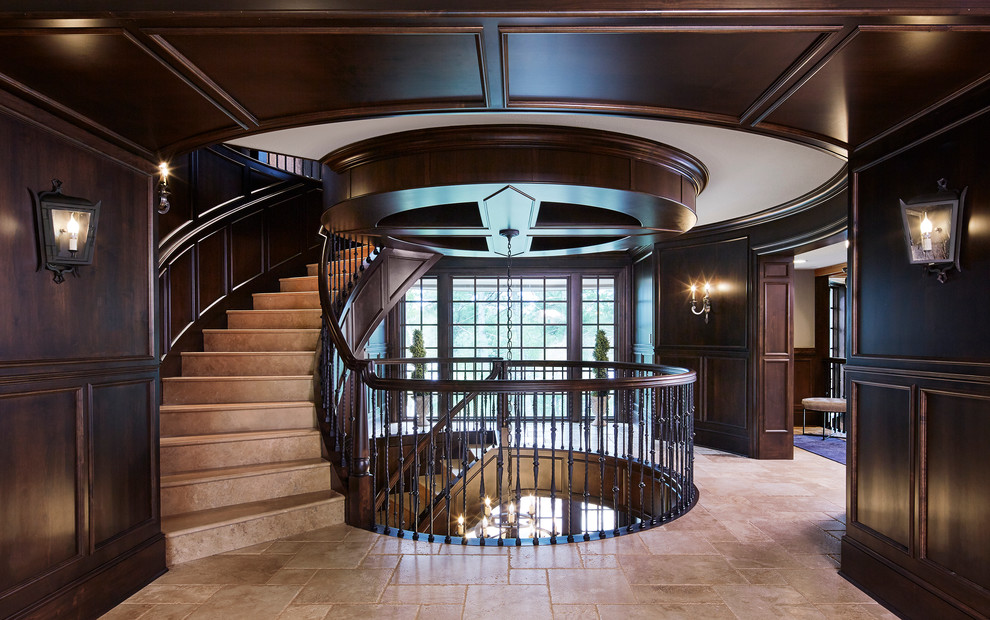 Пример оригинального дизайна: большая изогнутая лестница в классическом стиле с ступенями из известняка, подступенками из известняка и деревянными перилами