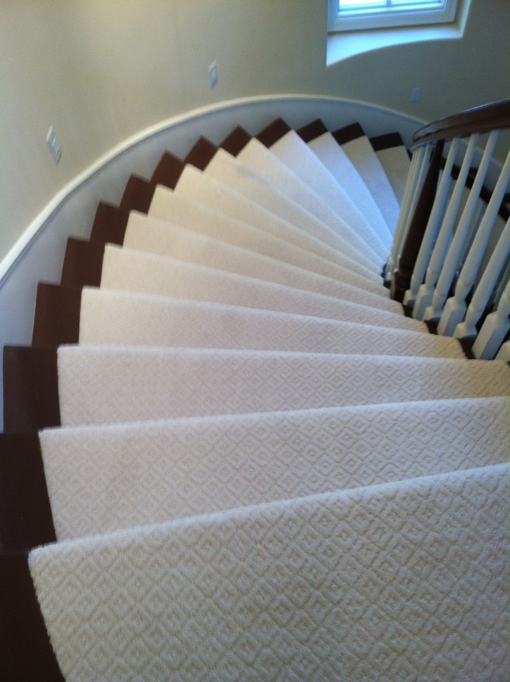Cette photo montre un escalier peint courbe de taille moyenne avec des marches en moquette.