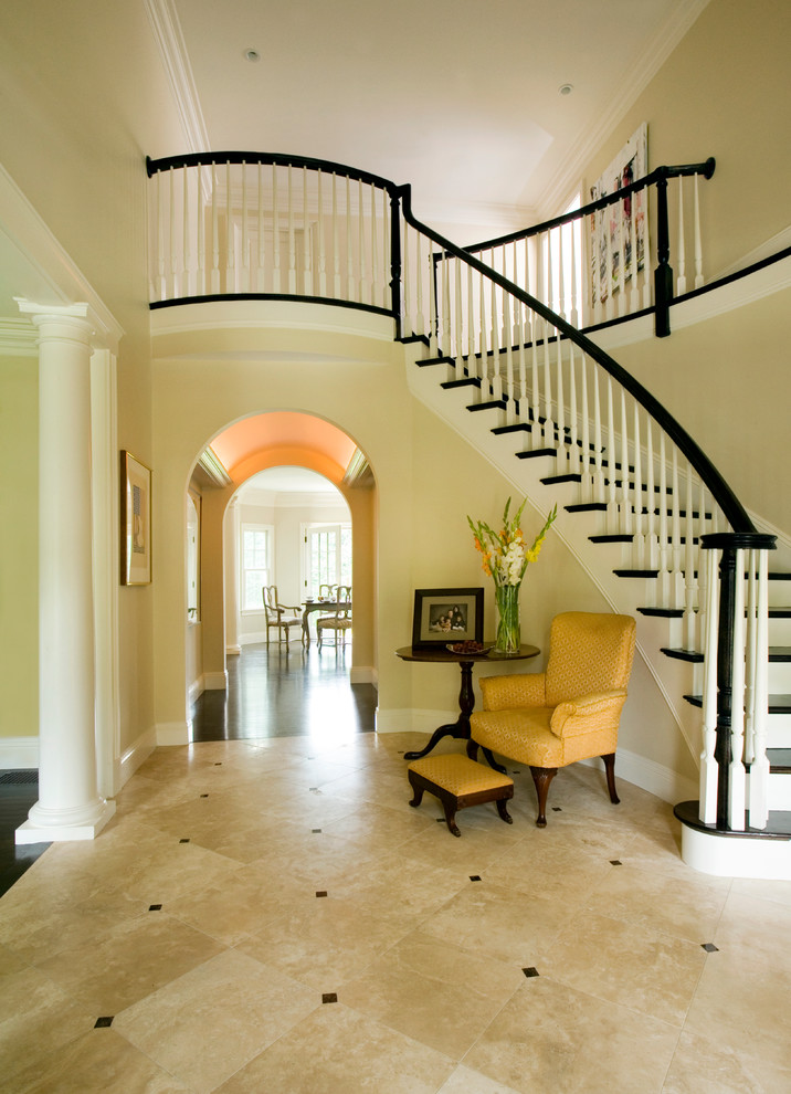 Стильный дизайн: большая изогнутая лестница в классическом стиле с крашенными деревянными ступенями и крашенными деревянными подступенками - последний тренд