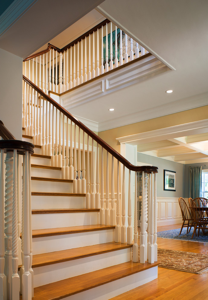 Идея дизайна: большая угловая лестница в классическом стиле с деревянными ступенями, крашенными деревянными подступенками и деревянными перилами