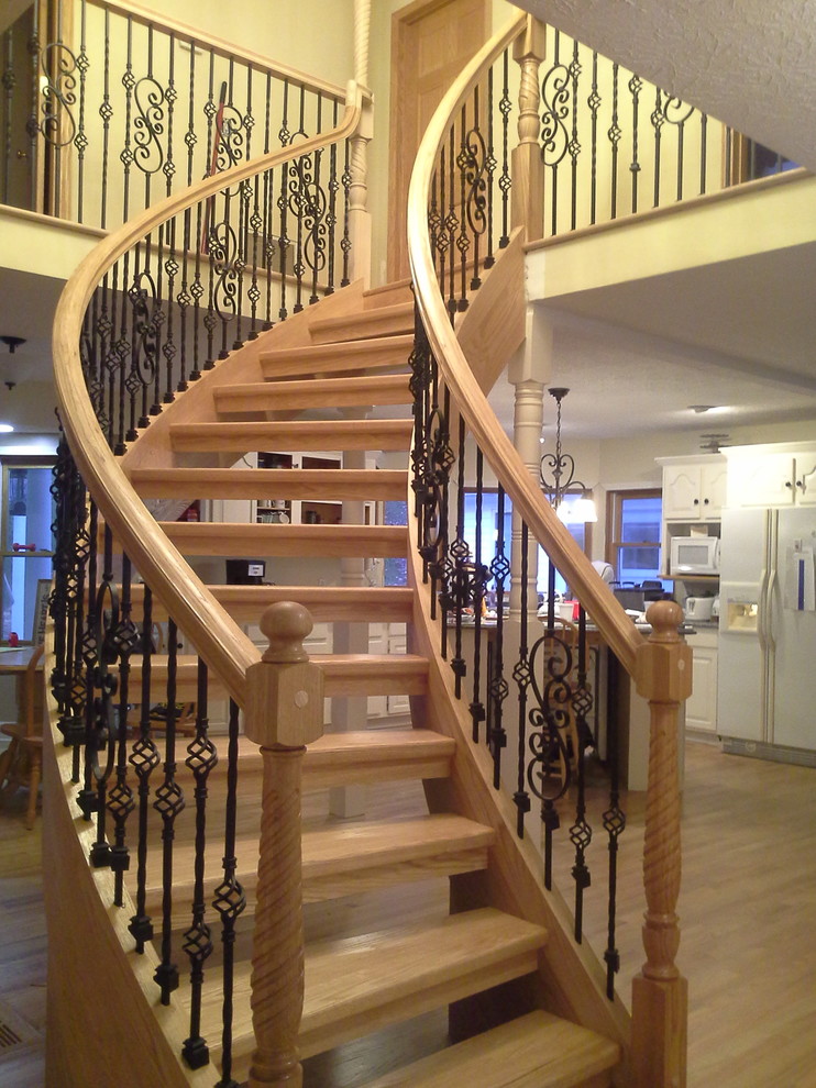 Foto de escalera curva de estilo americano de tamaño medio sin contrahuella con escalones de madera y barandilla de varios materiales