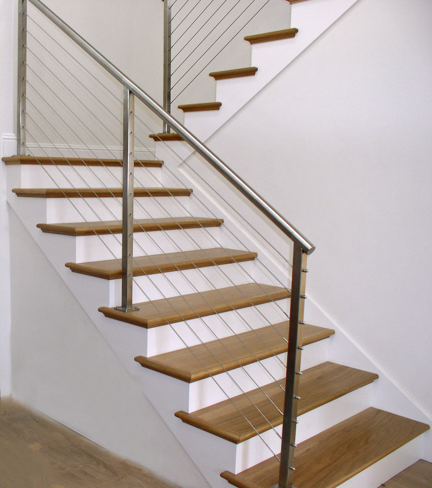 На фото: п-образная лестница среднего размера в современном стиле с деревянными ступенями, крашенными деревянными подступенками и перилами из тросов