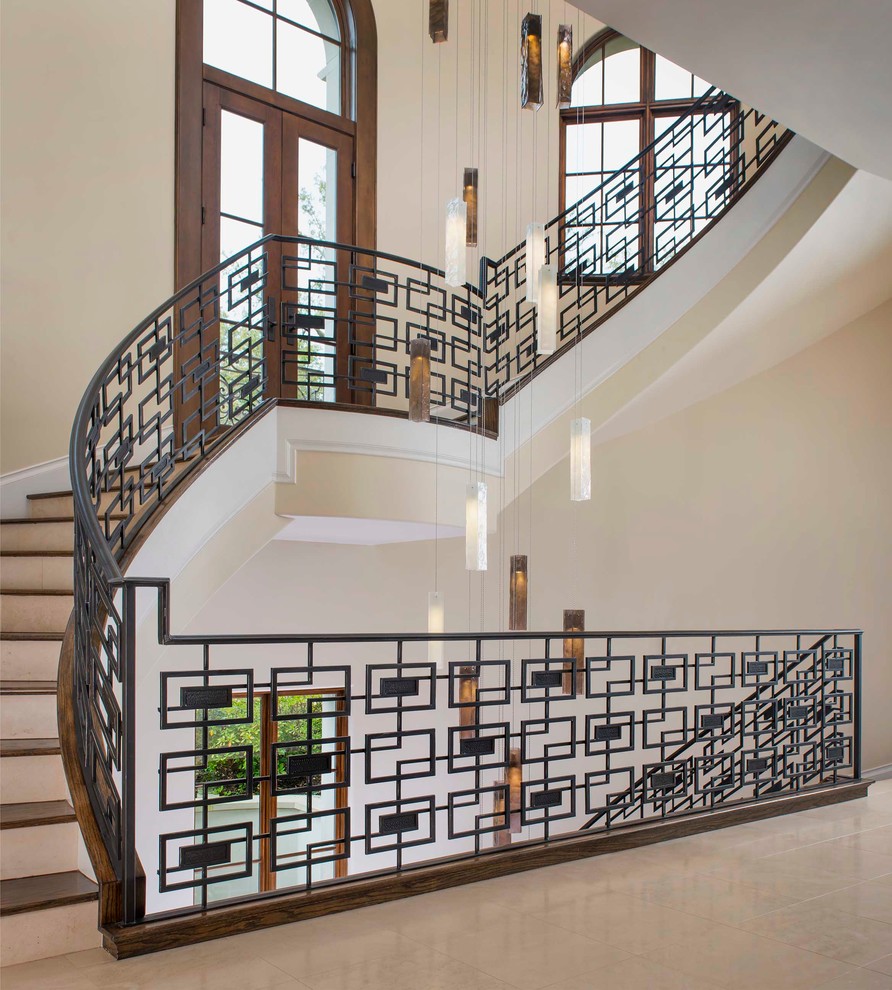 На фото: изогнутая лестница в стиле неоклассика (современная классика) с деревянными ступенями с