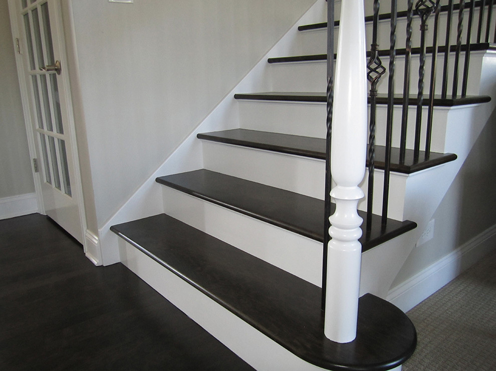 Inspiration pour un escalier traditionnel en U de taille moyenne avec des marches en bois, des contremarches en bois et un garde-corps en bois.