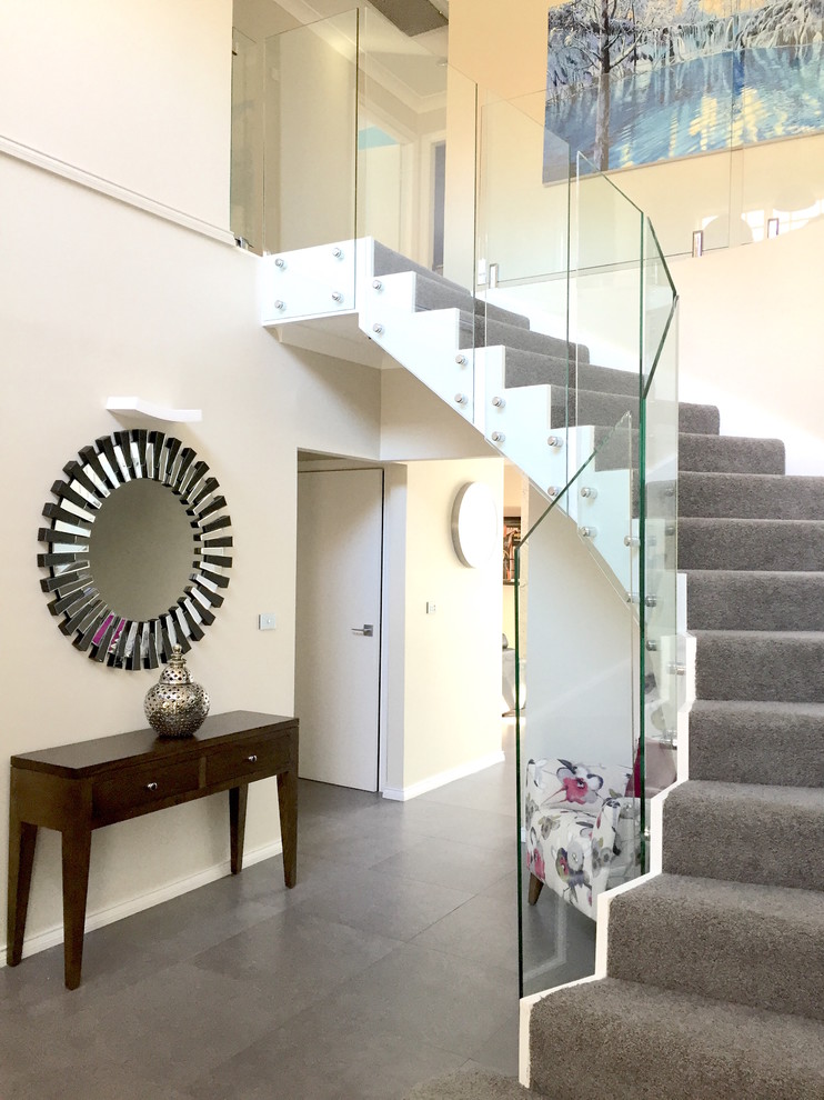 Example of a large trendy carpeted curved staircase design in Sydney with carpeted risers