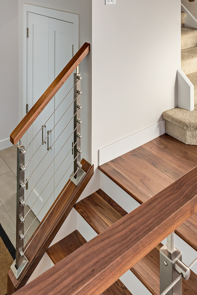 На фото: прямая лестница среднего размера в стиле неоклассика (современная классика) с деревянными ступенями и крашенными деревянными подступенками